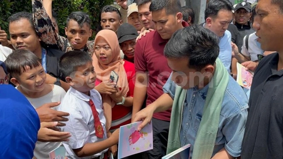 Gaya Gibran Kampanye di Kandang Anies, Kenakan Syal dan Bagi-bagi Buku